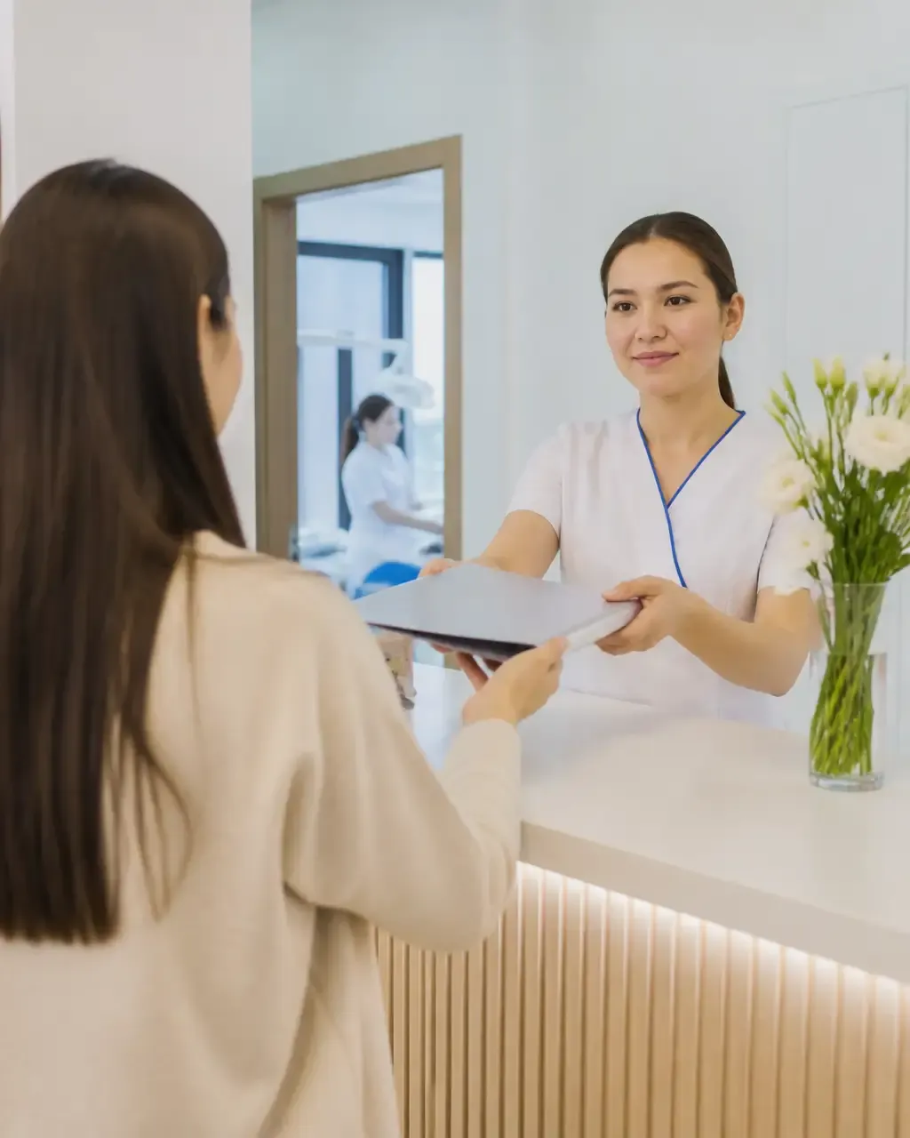 The clinic administrator gives the patient a treatment plan at the front desk