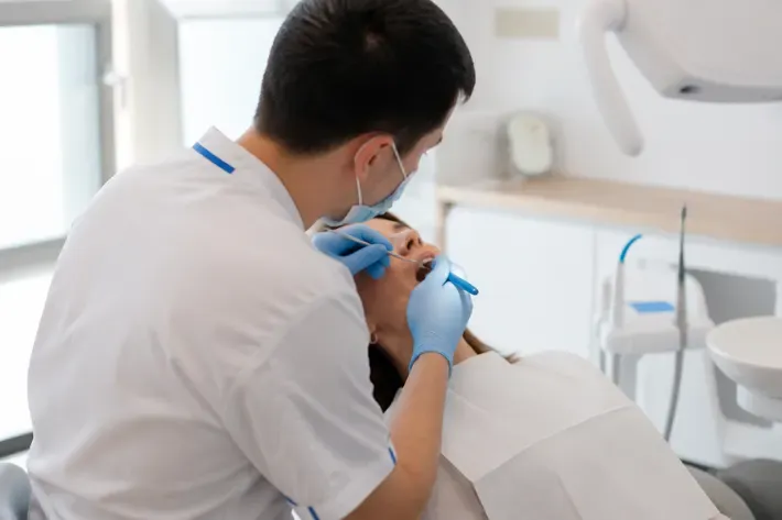 Chairside view: dentist at work, over-the-shoulder shot of the assistant — illustration for the section "Titanium post in tooth"