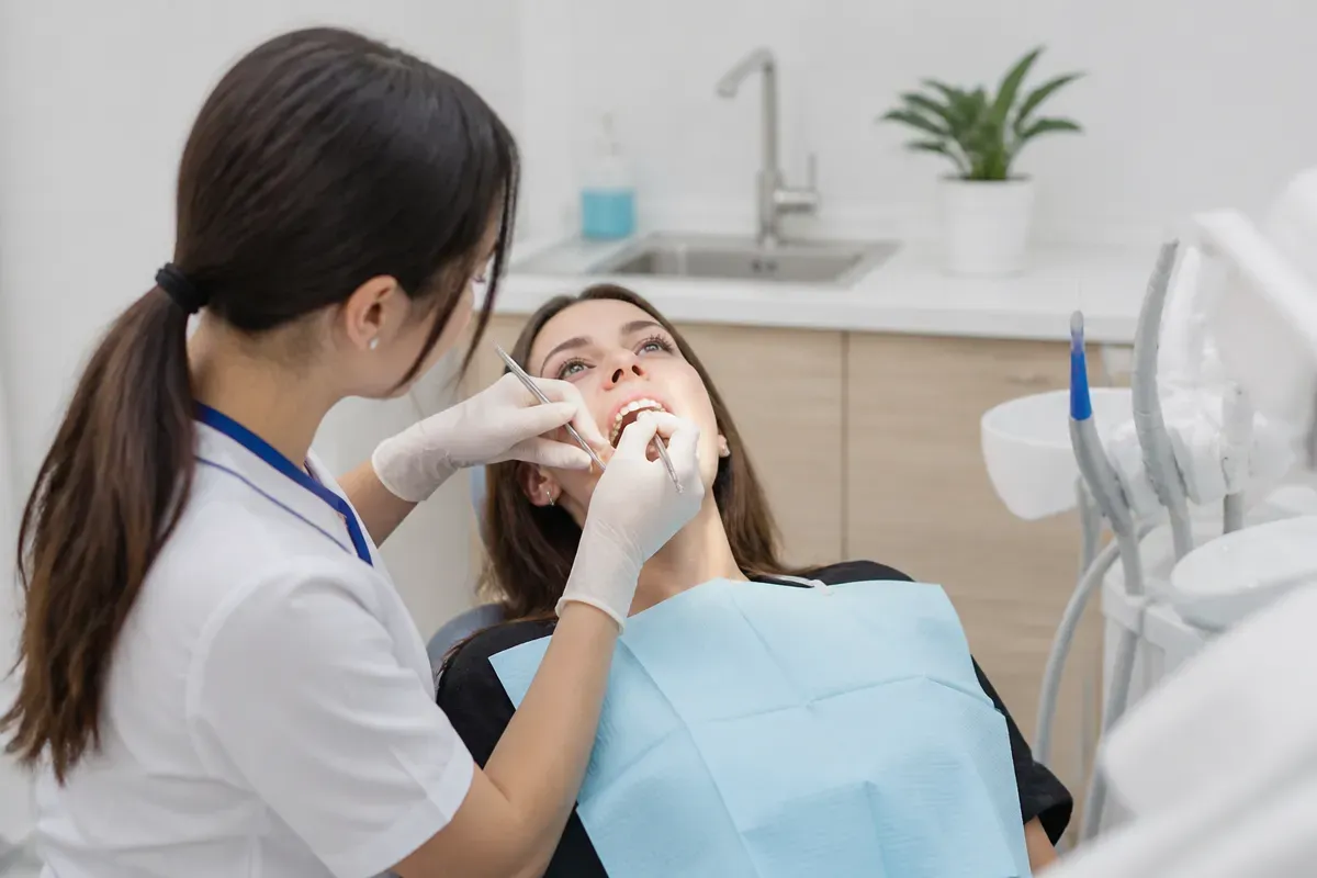 Chairside appointment: dentist at work, over-the-shoulder view of the assistant — illustration for the "Closed vestibuloplasty" section