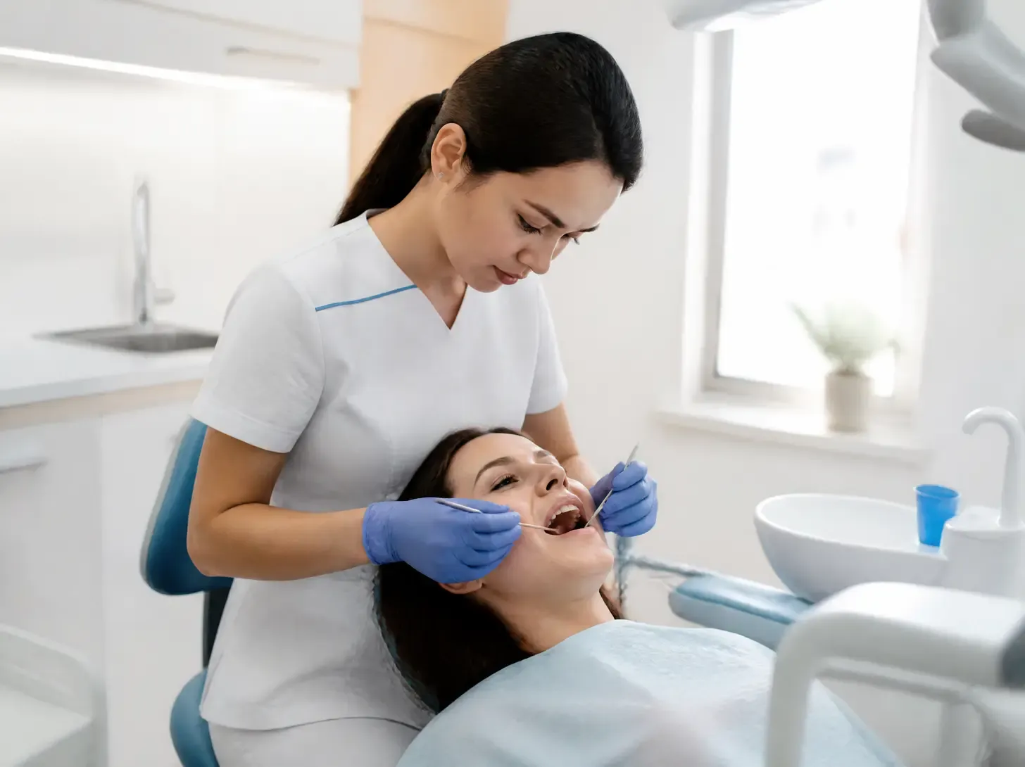 tooth enamel restoration — dentist shows the patient a treatment plan on screen in a bright office