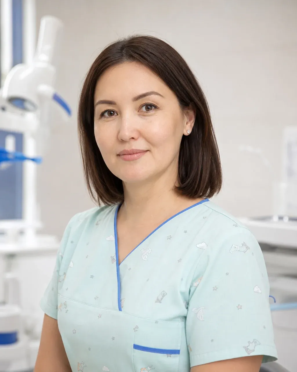 Әлімбекова Айгүл Серікбайқызы — Алматыдағы Dental-Center стоматологиялық клиникасының дәрігері, жұмыс киіміндегі портреті