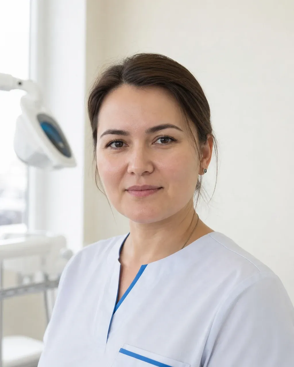 Бейсенова Айгерім Ерланқызы — Алматыдағы Dental-Center стоматологиялық клиникасының дәрігері, жұмыс киіміндегі портреті