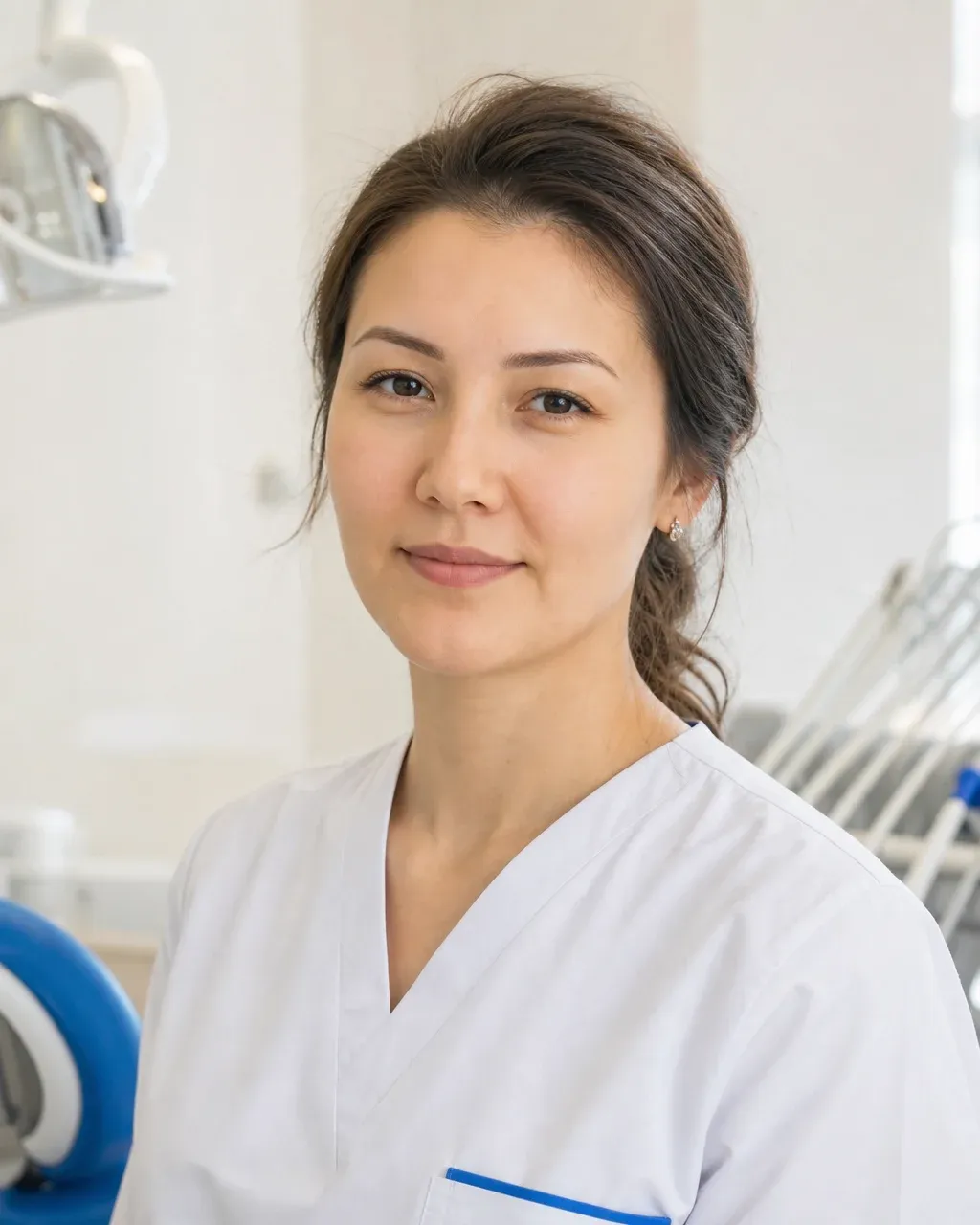 Ерғалиева Мадина Талғатқызы — Алматыдағы Dental-Center стоматологиялық клиникасының дәрігері, жұмыс киіміндегі портреті