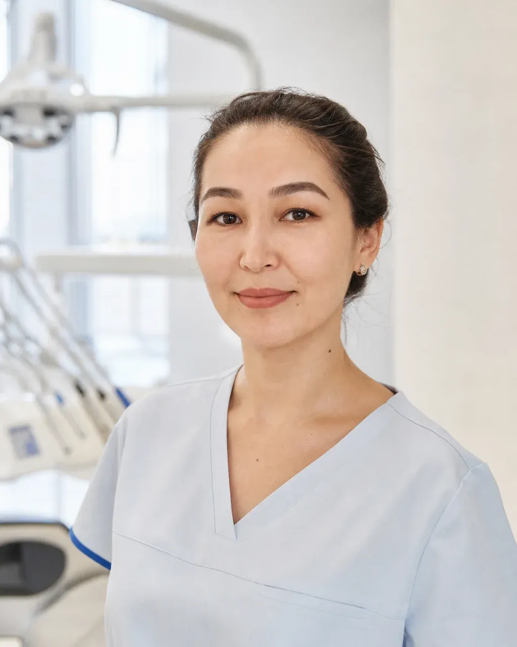 Исаева Алия Сериковна — Алматы қаласындағы Dental-Center стоматологиялық клиникасының дәрігері, жұмыс киіміндегі портреті