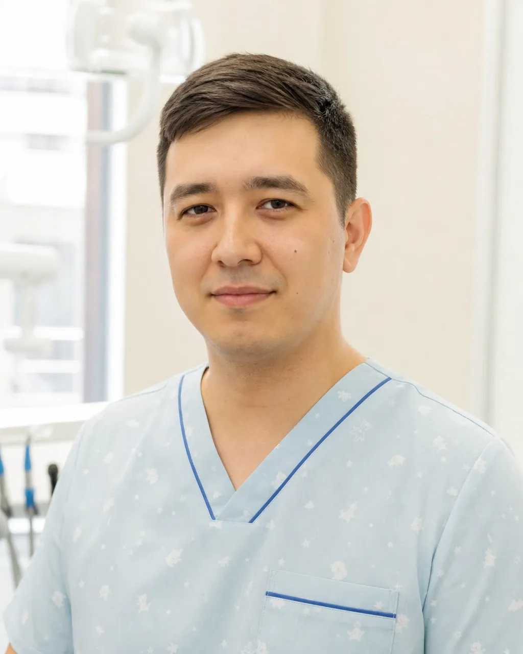 Нұржанов Дамир Ерболатұлы — Алматыдағы Dental-Center стоматологиялық клиникасының дәрігері, жұмыс киіміндегі портреті