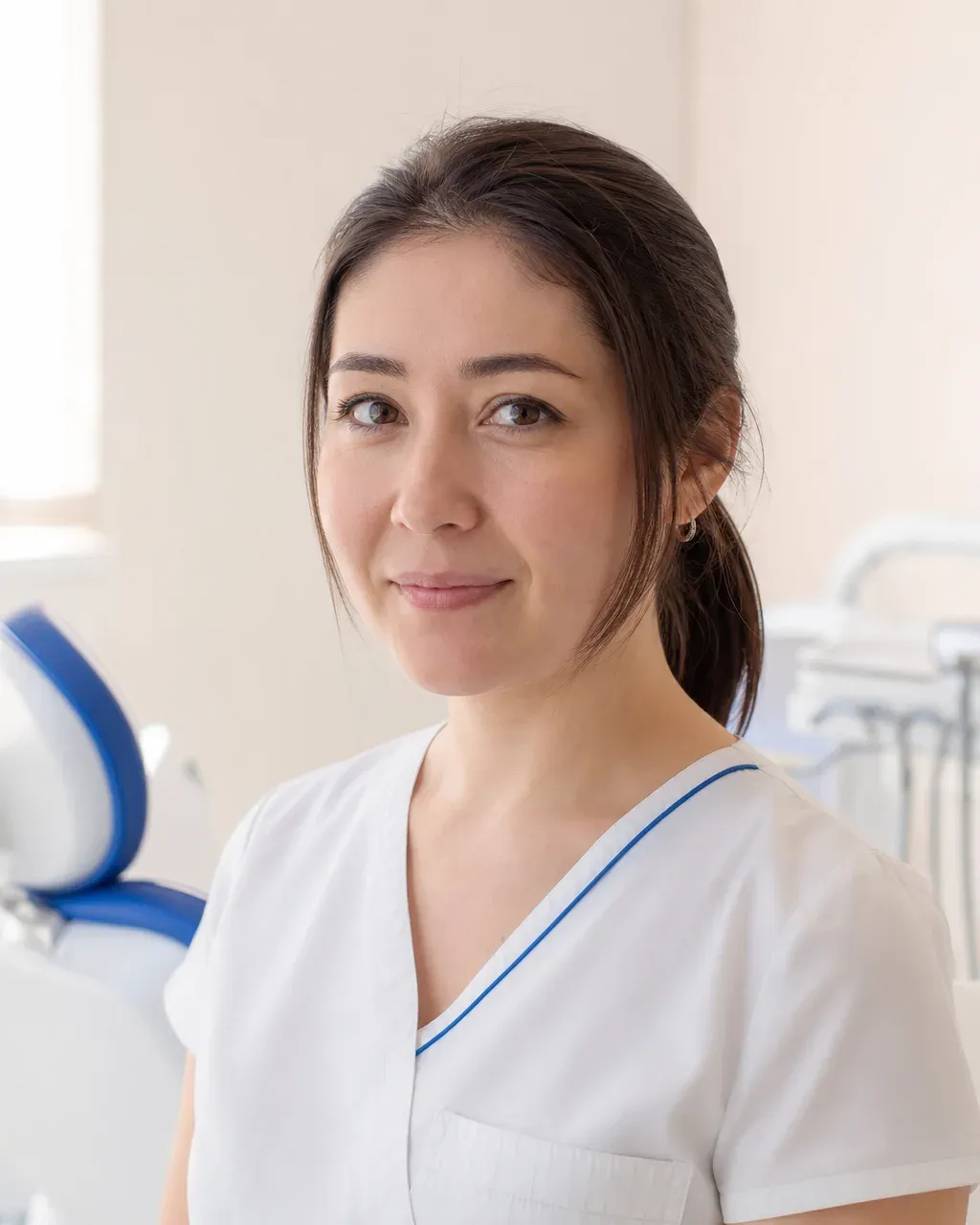 Оспанова Камила Нурланқызы — Алматы қаласындағы Dental-Center стоматологиялық клиникасының дәрігері, жұмыс киіміндегі портреті