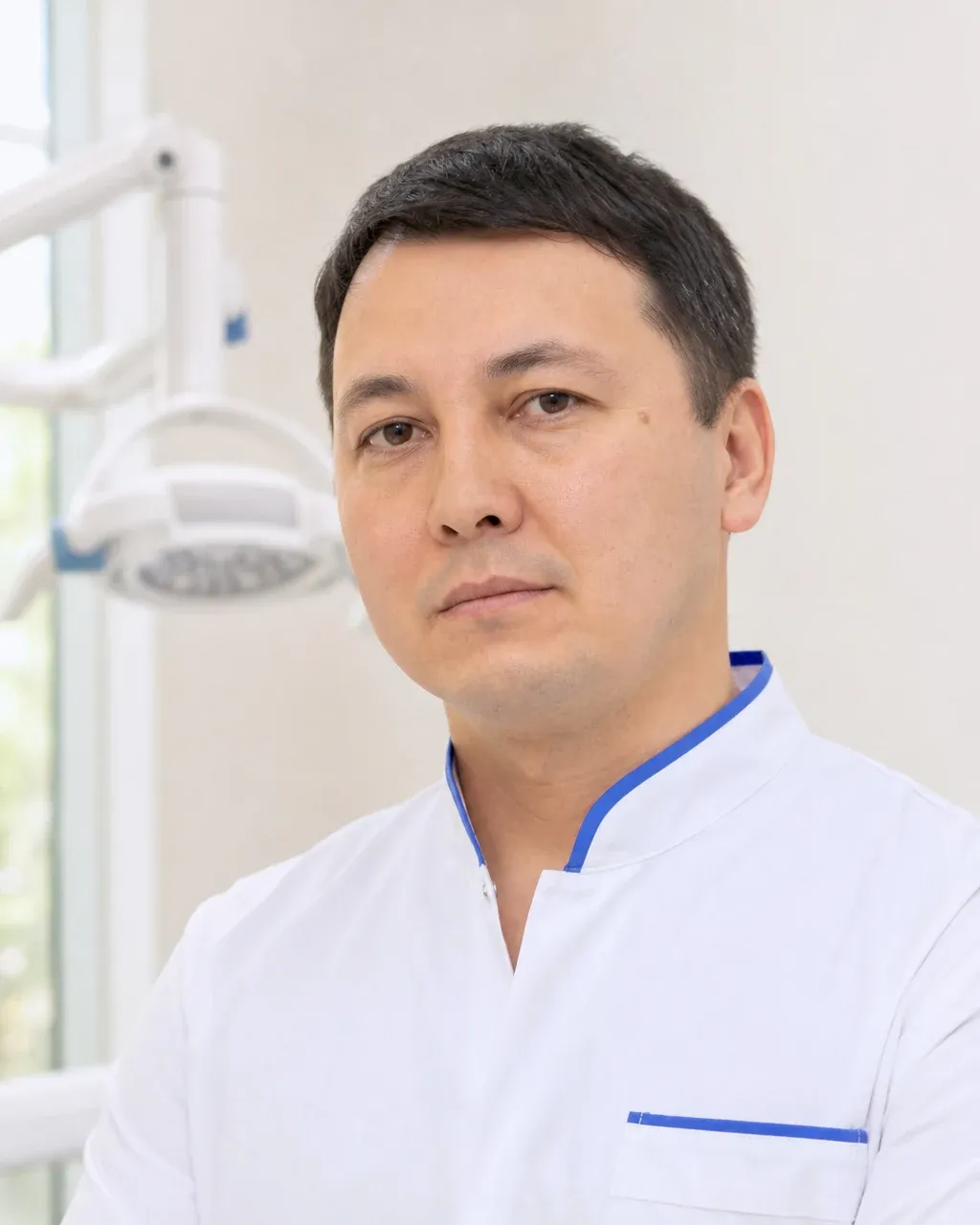 Жұмабеков Нұрлан Асылбекұлы — Алматы қаласындағы Dental-Center стоматологиялық клиникасының дәрігері, жұмыс киіміндегі портреті