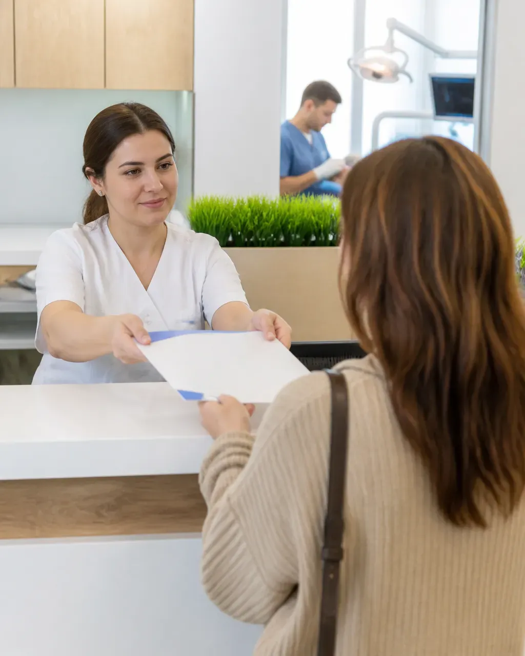The clinic administrator gives the patient a treatment plan at the front desk